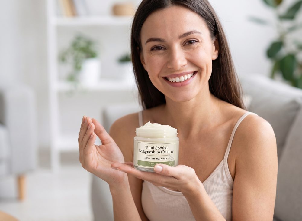 Smiling woman holding a jar of Total Soothe Magnesium Cream